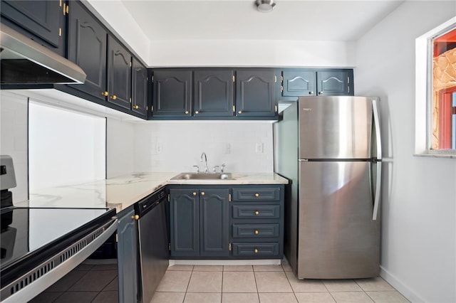 2850 N Powers Dr Unit 74, Orlando, FL 32818 - kitchen with appliances with stainless steel finishes, under cabinet range hood, tasteful backsplash, light tile patterned flooring, and light stone countertops
