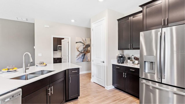 4792 Waltham Forest Dr, Davenport, FL 33837 - kitchen with appliances with stainless steel finishes, light countertops, light wood-type flooring, recessed lighting, and dark brown cabinets