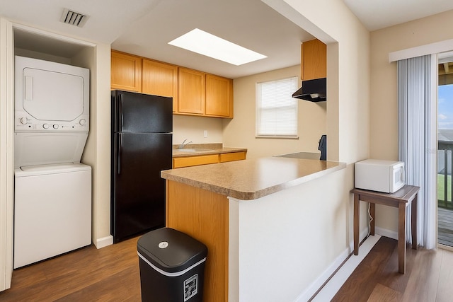 2791 L B Mcleod Rd Unit C, Orlando, FL 32805 - kitchen with freestanding refrigerator, stacked washing machine and dryer, a peninsula, and dark wood-style flooring