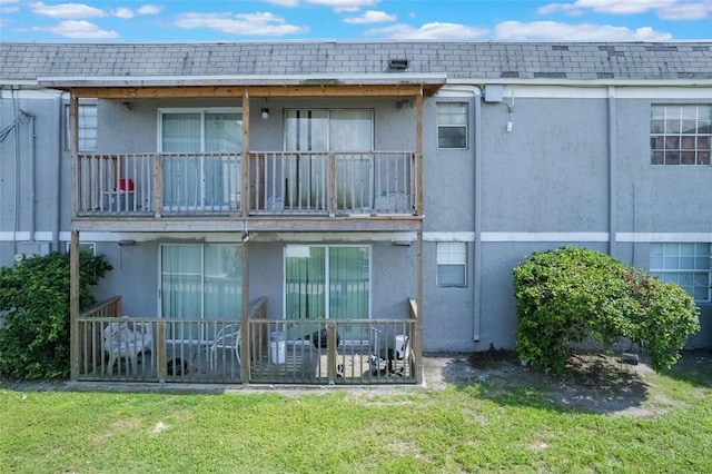 2791 L B Mcleod Rd Unit C, Orlando, FL 32805 - back of house featuring stucco siding, a lawn, a balcony, and a shingled roof