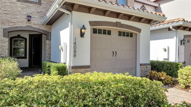 14088 Tarvin St, Orlando, FL 32832 - view of exterior entry featuring stone siding, stucco siding, an attached garage, and a tiled roof