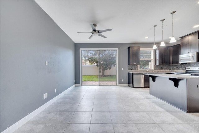 14088 Tarvin St, Orlando, FL 32832 - kitchen featuring white microwave, electric range oven, dishwasher, decorative backsplash, and dark brown cabinetry