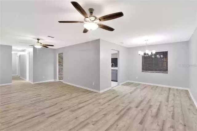 15609 Timberline Dr, Tampa, FL 33624 - unfurnished living room with a chandelier, a ceiling fan, and light wood-style floors