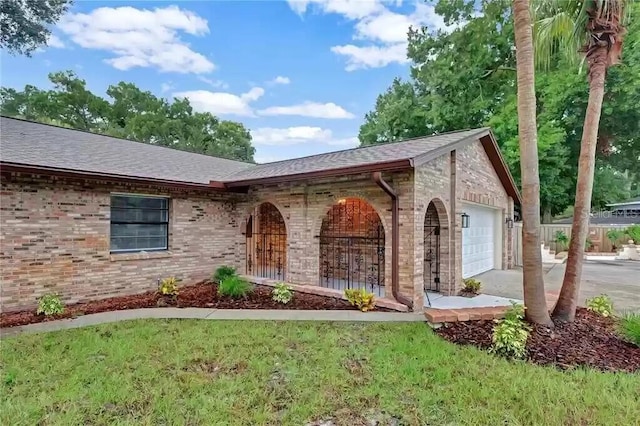 15609 Timberline Dr, Tampa, FL 33624 - view of front of home with brick siding, an attached garage, roof with shingles, and driveway