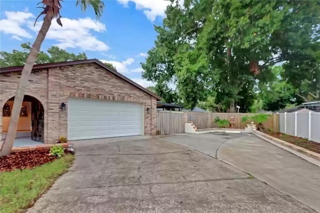 15609 Timberline Dr, Tampa, FL 33624 - view of side of property with driveway, an attached garage, and brick siding