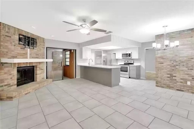 15609 Timberline Dr, Tampa, FL 33624 - kitchen with appliances with stainless steel finishes, ceiling fan, light countertops, open floor plan, and a peninsula