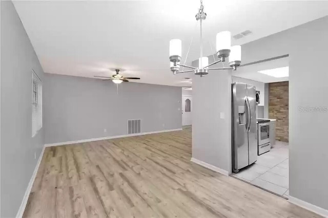 15609 Timberline Dr, Tampa, FL 33624 - kitchen with appliances with stainless steel finishes, a chandelier, a ceiling fan, light wood-style flooring, and decorative light fixtures