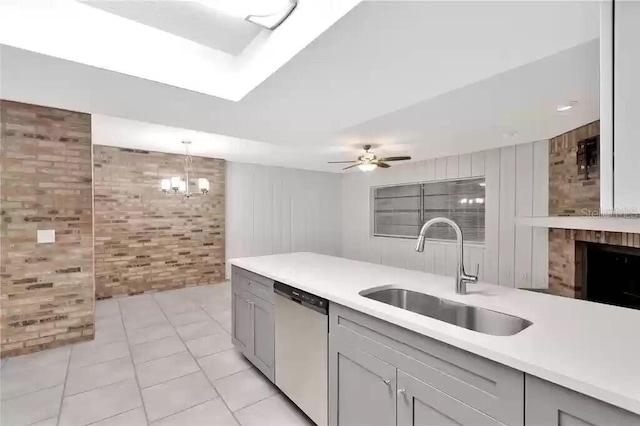 15609 Timberline Dr, Tampa, FL 33624 - kitchen with dishwashing machine, brick wall, light countertops, gray cabinetry, and light tile patterned floors