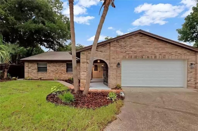 15609 Timberline Dr, Tampa, FL 33624 - view of front of house with concrete driveway, a front lawn, brick siding, and an attached garage