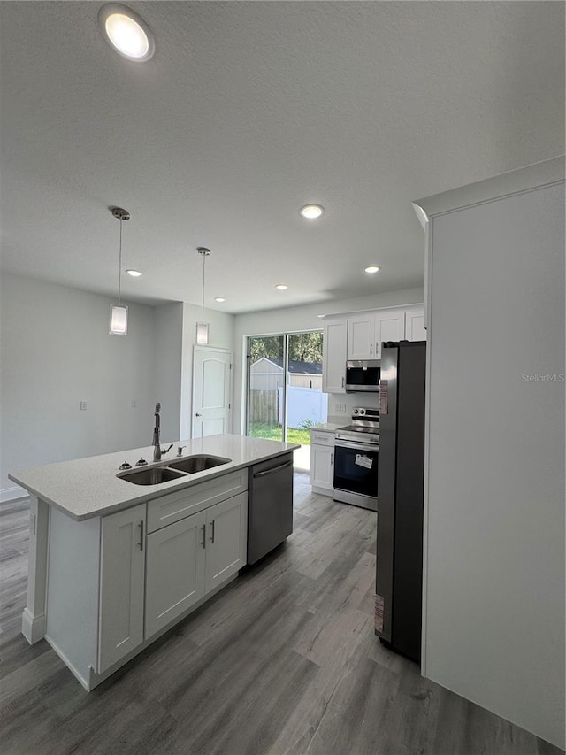 320 W Necho Ave, Lake Alfred, FL 33850 - kitchen with stainless steel appliances, dark wood-type flooring, white cabinets, a center island with sink, and light countertops