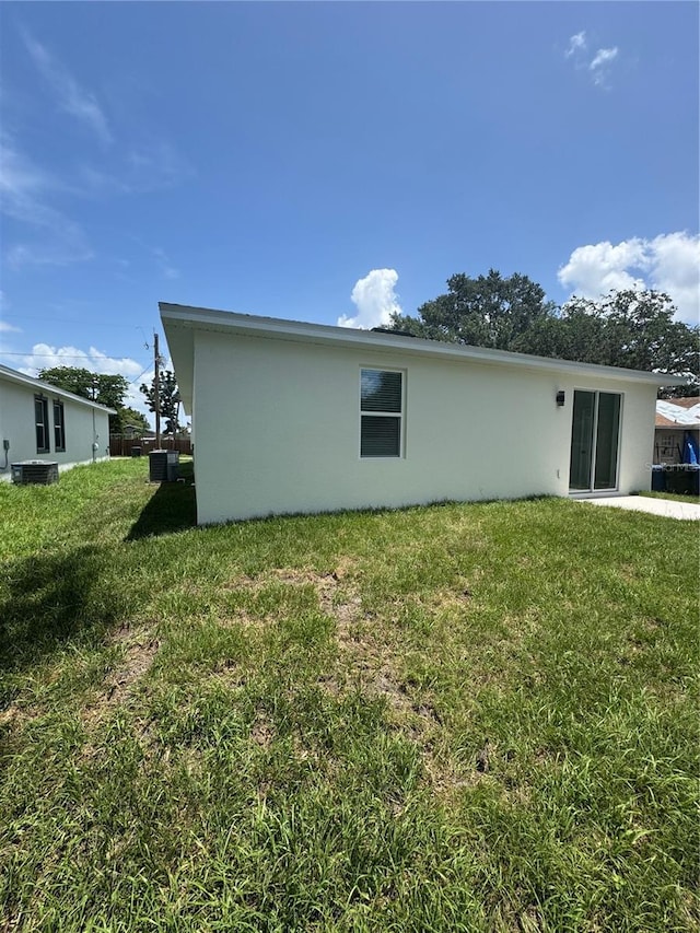 320 W Necho Ave, Lake Alfred, FL 33850 - view of property exterior with stucco siding and a lawn