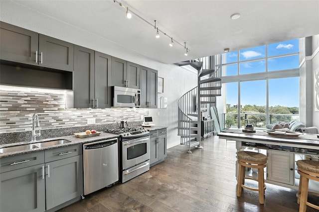 150 E Robinson St Unit 407, Orlando, FL 32801 - kitchen with stainless steel appliances, gray cabinetry, tasteful backsplash, light stone countertops, and dark wood-type flooring