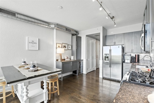 150 E Robinson St Unit 407, Orlando, FL 32801 - kitchen featuring stainless steel refrigerator with ice dispenser, gray cabinets, a textured ceiling, dark wood-style flooring, and a textured wall