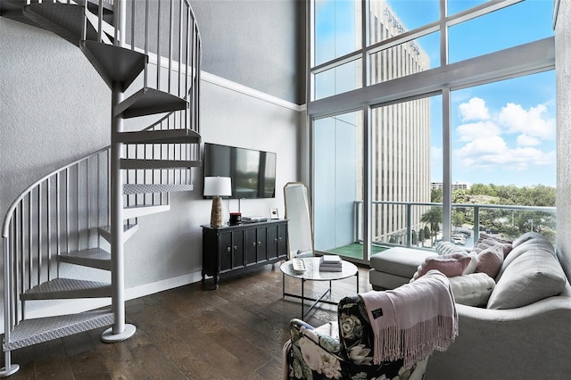 150 E Robinson St Unit 407, Orlando, FL 32801 - living area featuring hardwood / wood-style floors, a towering ceiling, plenty of natural light, a textured wall, and stairs