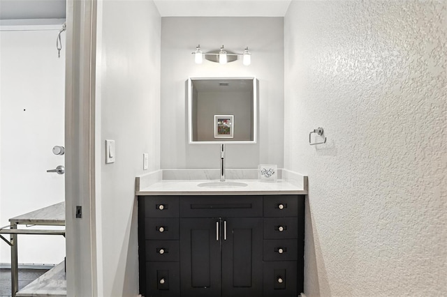150 E Robinson St Unit 407, Orlando, FL 32801 - bathroom featuring vanity and a textured wall