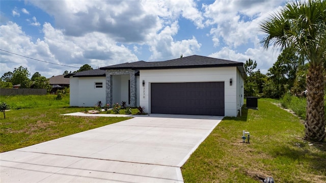 3270 Framinghan Ave SW, Palm Bay, FL 32908 - view of front of house featuring a garage, concrete driveway, a front lawn, stone siding, and stucco siding