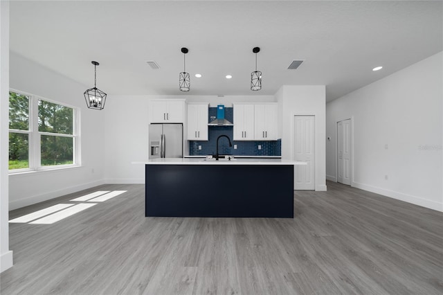 3270 Framinghan Ave SW, Palm Bay, FL 32908 - kitchen with stainless steel refrigerator with ice dispenser, wall chimney range hood, light countertops, recessed lighting, and an island with sink