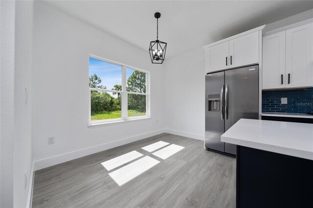 3270 Framinghan Ave SW, Palm Bay, FL 32908 - kitchen featuring stainless steel fridge, a chandelier, light countertops, light wood finished floors, and hanging light fixtures