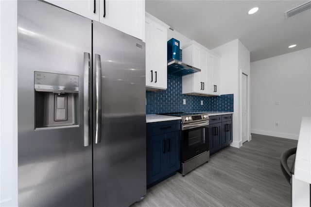 3270 Framinghan Ave SW, Palm Bay, FL 32908 - kitchen featuring stainless steel appliances, light countertops, light wood-style floors, white cabinetry, and wall chimney exhaust hood