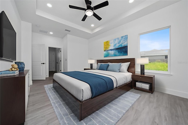 3270 Framinghan Ave SW, Palm Bay, FL 32908 - bedroom featuring light wood finished floors, recessed lighting, a tray ceiling, and ceiling fan