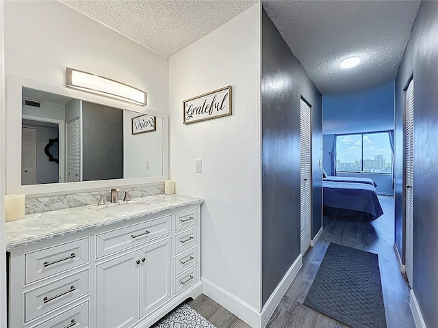 400 E Colonial Dr Unit 1501, Orlando, FL 32803 - bathroom with a textured ceiling, wood finished floors, vanity, and connected bathroom