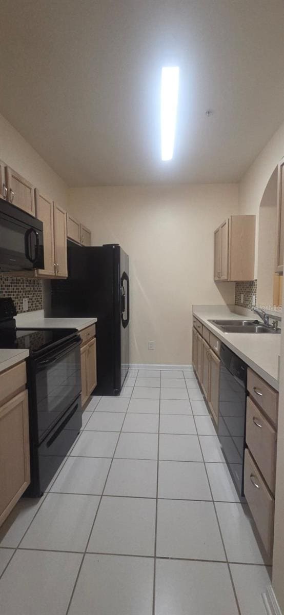 13584 Turtle Marsh Loop Unit 12, Orlando, FL 32837 - kitchen featuring black appliances, tasteful backsplash, light tile patterned floors, light countertops, and arched walkways