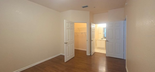13584 Turtle Marsh Loop Unit 12, Orlando, FL 32837 - unfurnished bedroom with dark wood-type flooring, a spacious closet, and a closet