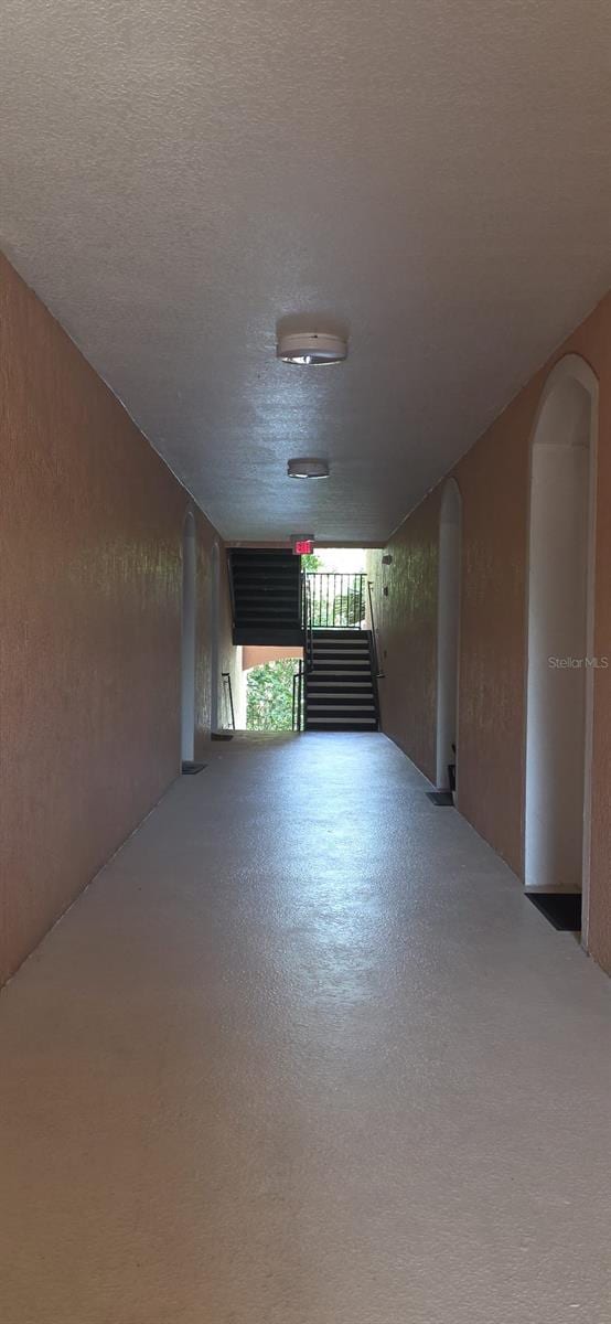 13584 Turtle Marsh Loop Unit 12, Orlando, FL 32837 - corridor with arched walkways, a textured ceiling, finished concrete flooring, and a textured wall
