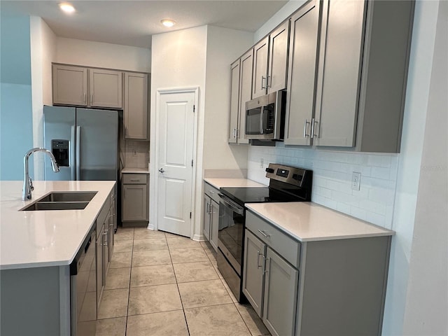 1950 Birnham Wood Bnd, Kissimmee, FL 34746 - kitchen with appliances with stainless steel finishes, gray cabinets, tasteful backsplash, light countertops, and recessed lighting