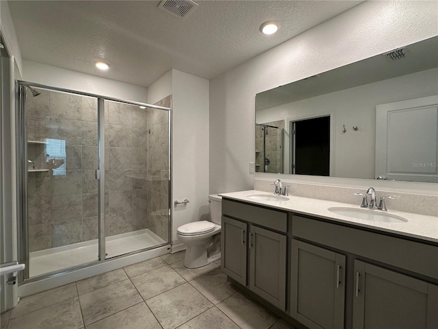 1950 Birnham Wood Bnd, Kissimmee, FL 34746 - bathroom featuring double vanity, a shower stall, a textured ceiling, tile patterned floors, and recessed lighting