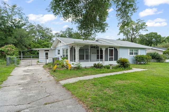 2538 Meadowview Ln, Deland, FL 32720 - ranch-style house featuring a gate, a sunroom, driveway, a carport, and roof with shingles
