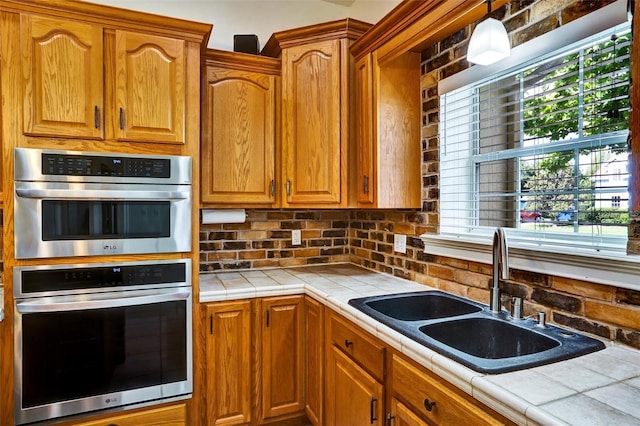 205 Trail Bridge Ct, Winter Garden, FL 34787 - kitchen with tile counters, double oven, decorative backsplash, and brown cabinetry