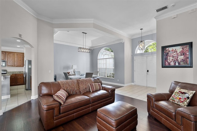 3711 Half Moon Dr, Orlando, FL 32812 - living room with a chandelier, light wood finished floors, arched walkways, and crown molding
