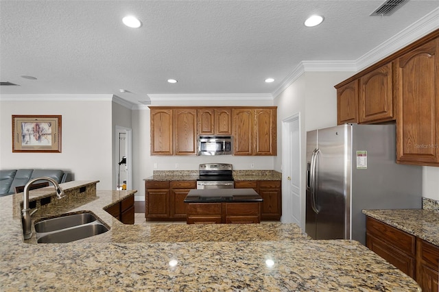 3711 Half Moon Dr, Orlando, FL 32812 - kitchen with appliances with stainless steel finishes, a center island, ornamental molding, light stone countertops, and recessed lighting