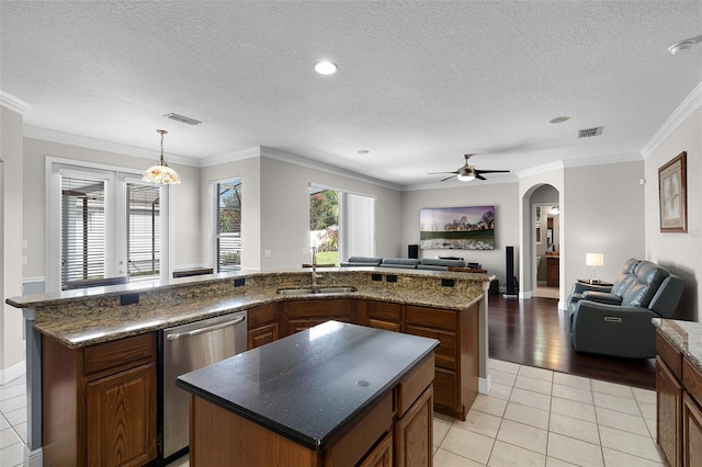 3711 Half Moon Dr, Orlando, FL 32812 - kitchen with stainless steel dishwasher, a center island, open floor plan, ceiling fan, and a textured ceiling