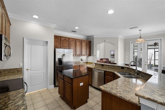 3711 Half Moon Dr, Orlando, FL 32812 - kitchen featuring stainless steel appliances, arched walkways, a kitchen island, a textured ceiling, and light tile patterned floors