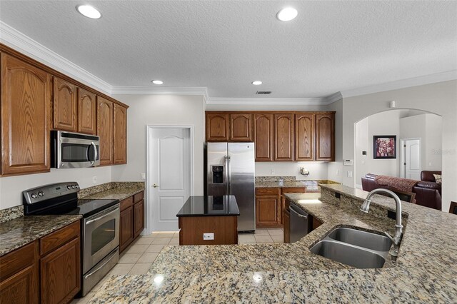 3711 Half Moon Dr, Orlando, FL 32812 - kitchen featuring appliances with stainless steel finishes, a kitchen island, light tile patterned floors, crown molding, and dark stone countertops