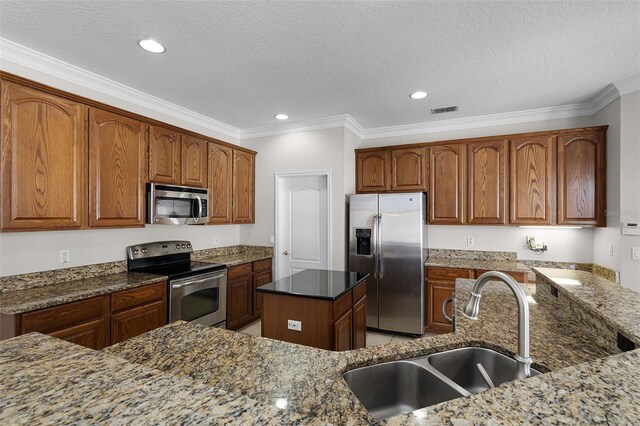 3711 Half Moon Dr, Orlando, FL 32812 - kitchen featuring stainless steel appliances, ornamental molding, dark stone counters, a textured ceiling, and brown cabinets