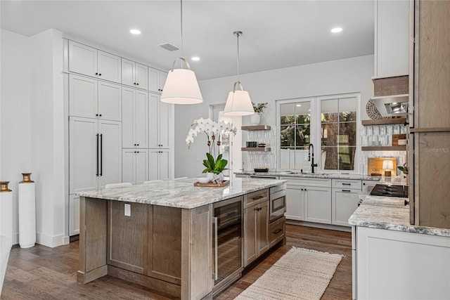 1780 Mizell Ave, Winter Park, FL 32789 - kitchen with wine cooler, open shelves, dark wood finished floors, a center island, and light stone counters