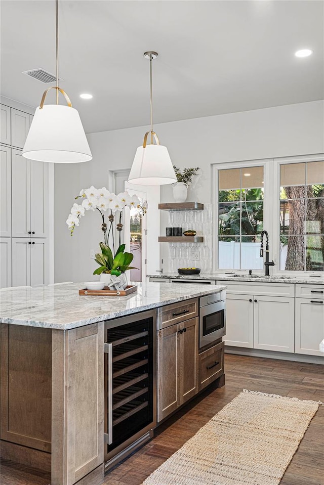 1780 Mizell Ave, Winter Park, FL 32789 - kitchen with beverage cooler, a kitchen island, dark wood-type flooring, light stone counters, and recessed lighting