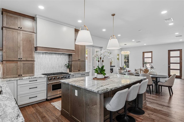 1780 Mizell Ave, Winter Park, FL 32789 - kitchen with stainless steel stove, decorative backsplash, a kitchen island, plenty of natural light, and recessed lighting