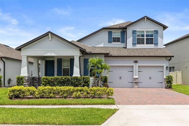 12216 Encore At Ovation Way, Winter Garden, FL 34787 - view of front of property with roof with shingles, decorative driveway, an attached garage, and stone siding