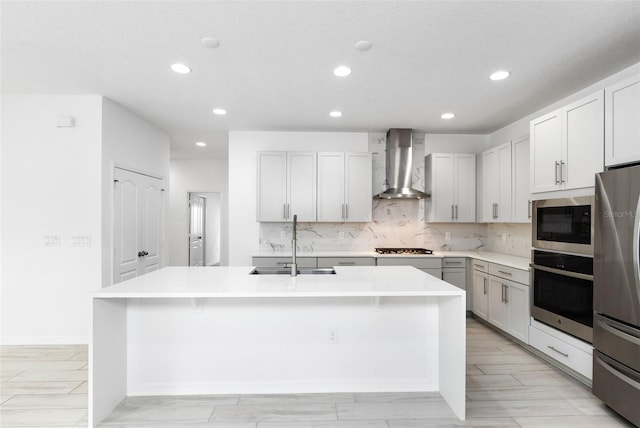 12216 Encore At Ovation Way, Winter Garden, FL 34787 - kitchen with wall chimney exhaust hood, appliances with stainless steel finishes, recessed lighting, a center island with sink, and backsplash