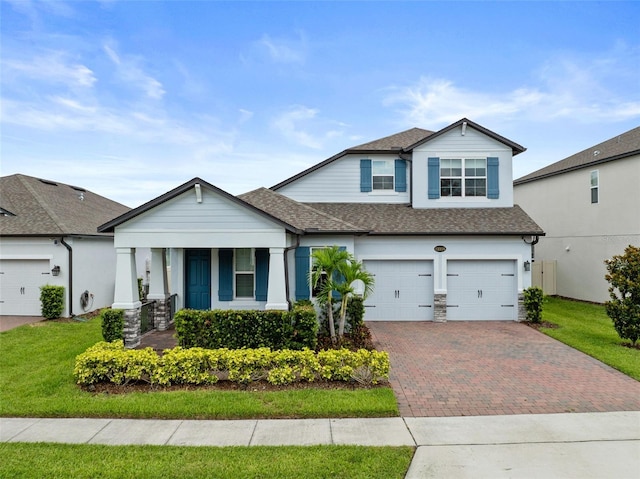 12216 Encore At Ovation Way, Winter Garden, FL 34787 - view of front facade featuring roof with shingles, decorative driveway, a porch, and a front yard