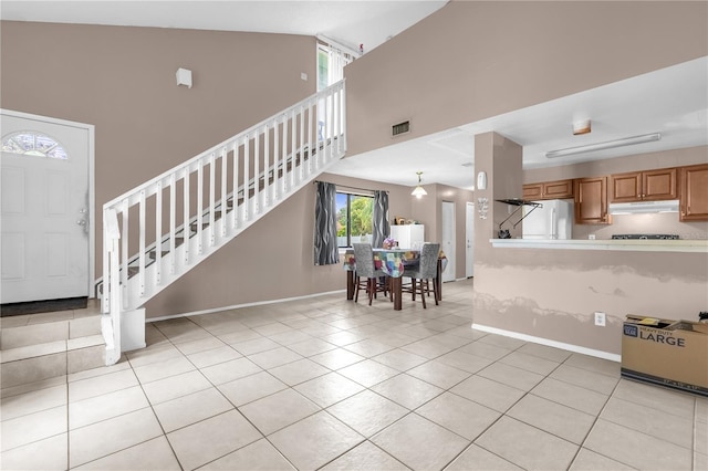 2728 Tally Ho Ave 2722, 2724, 2726, Orlando, FL 32826 - kitchen featuring under cabinet range hood, white fridge, light tile patterned floors, high vaulted ceiling, and light countertops