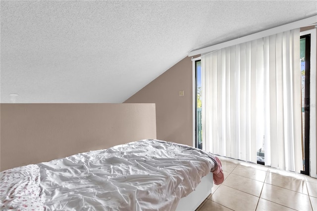 2728 Tally Ho Ave 2722, 2724, 2726, Orlando, FL 32826 - bedroom featuring a textured ceiling, lofted ceiling, tile patterned floors, and access to exterior