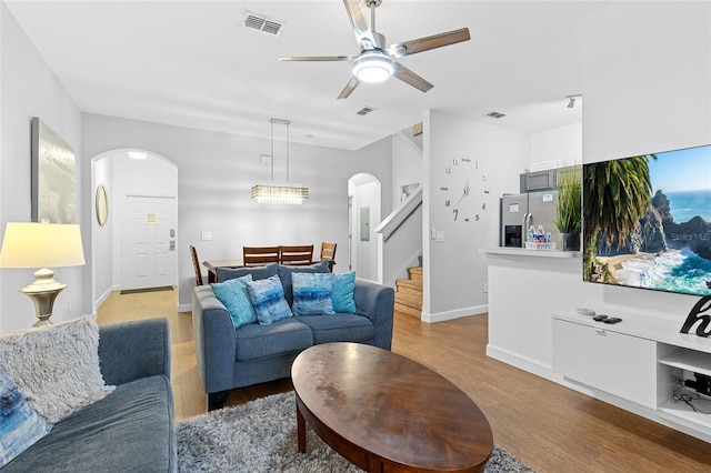 814 Calabria Ave, Davenport, FL 33897 - living area featuring arched walkways, stairs, light wood-type flooring, and a ceiling fan
