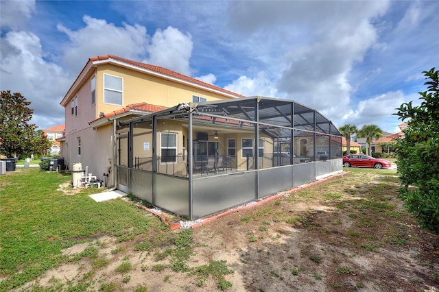148 Miro Dr, Davenport, FL 33837 - back of property with a tile roof, a lawn, a ceiling fan, a lanai, and stucco siding