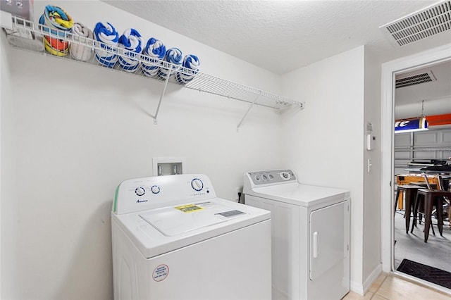 148 Miro Dr, Davenport, FL 33837 - laundry room with independent washer and dryer, light tile patterned flooring, and a textured ceiling