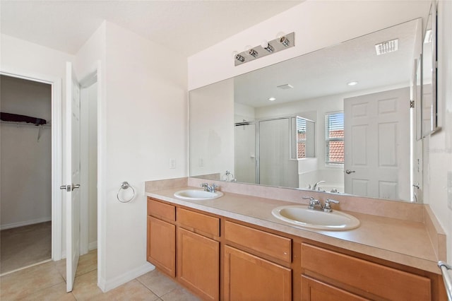 148 Miro Dr, Davenport, FL 33837 - bathroom featuring a shower stall, a walk in closet, tile patterned flooring, double vanity, and a bath